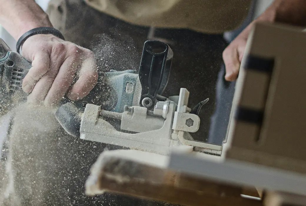 Mains d'un homme en train de scier dans une menuiserie.